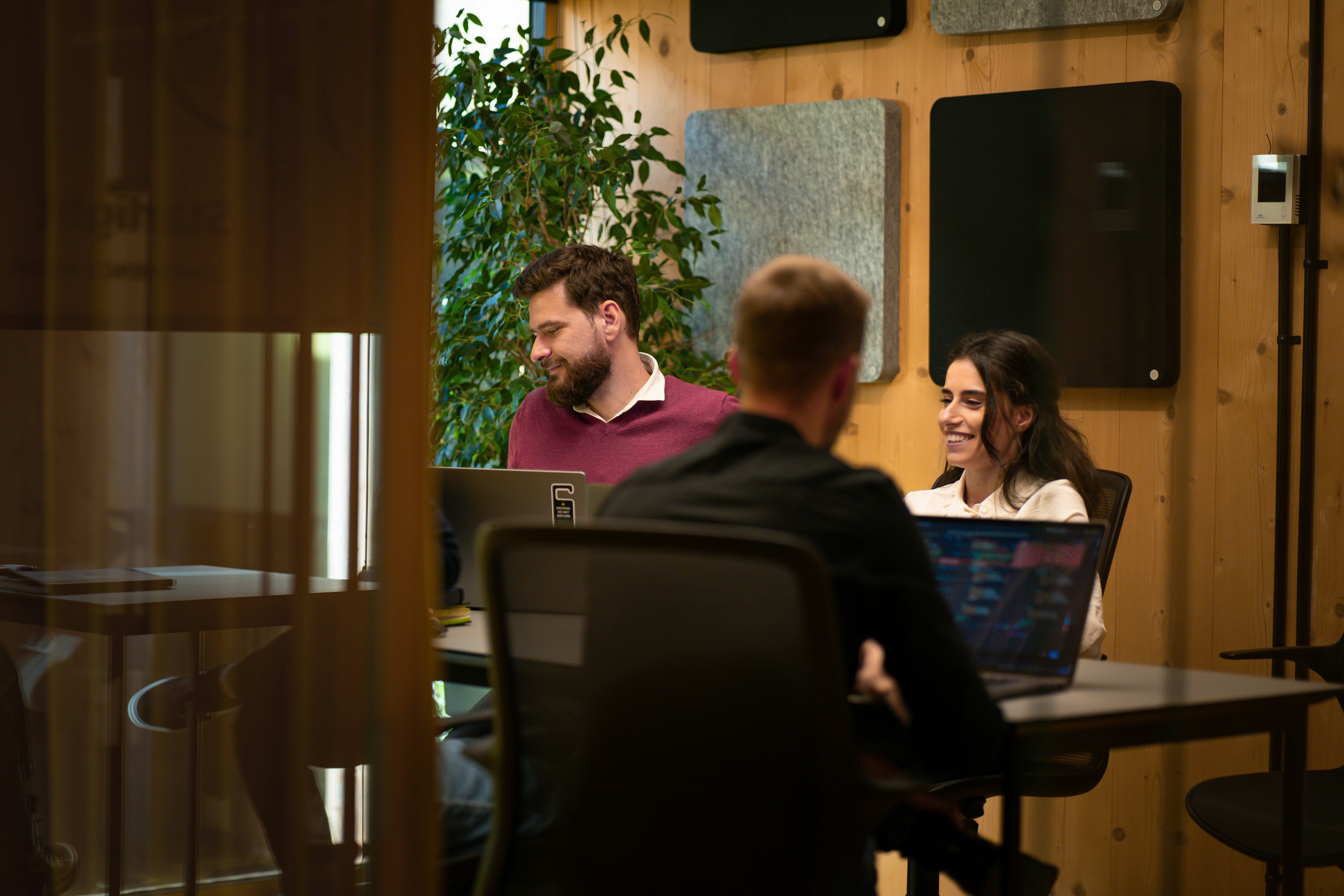 People meeting in a modern office with a laptop open on the table.